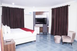 Un dormitorio con una cama, un escritorio y un televisor. en Chateux de atlantique Hotel, en Lagos