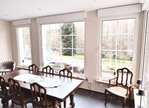 a dining room with a table and chairs and windows at Domaine de la Brême 