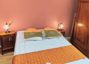 a bedroom with a bed with two lamps on two tables at Domaine de la Brême 