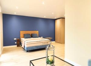a bedroom with a bed with a blue wall at Domaine de la Brême 