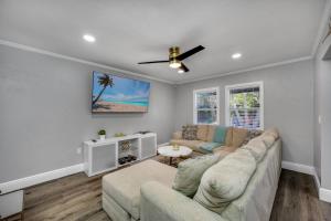een woonkamer met een bank en een plafondventilator bij Tampa Retreat with Heated In-Ground Pool & Spa in Tampa