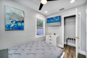 een slaapkamer met een bed en een schilderij aan de muur bij Tampa Retreat with Heated In-Ground Pool & Spa in Tampa +52 foto's