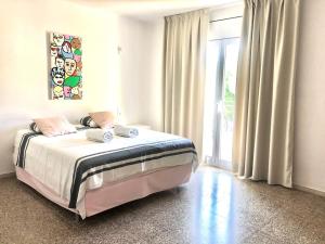 een slaapkamer met een bed en een groot raam bij Global Immo 9101 Pacheco Beach in Roses +65 foto's