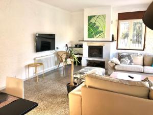 een woonkamer met een bank en een tv bij Global Immo 9101 Pacheco Beach in Roses