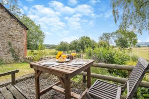 a wooden table and chairs on the patio of a house at 1 Bed in Leintwardine oc-b29785 in Brampton Bryan