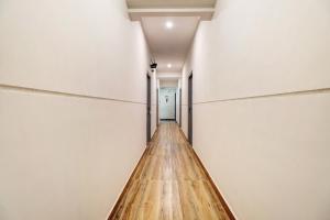 a long wooden floor in a room with white walls at Townhouse Ecity Inn in Bangalore +29 photos