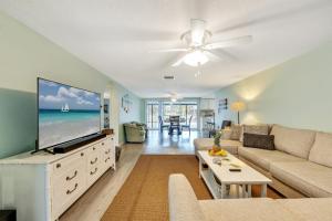 a living room with a couch and a flat screen tv at Cozy Oasis Screened Pool Picturesque Water Canal Views! in Port Richey