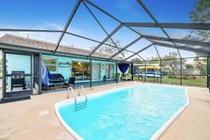 a swimming pool in a house with a glass roof at Cozy Oasis Screened Pool Picturesque Water Canal Views! in Port Richey