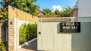 ein weißes Tor mit einem Schild darauf neben einem Zaun in der Unterkunft Mimi Rae Villa Canggu in Dalung