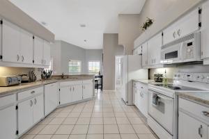 a large kitchen with white cabinets and white appliances at Pool Waterfront Lake 12 PPL Gorgeous in Riverview