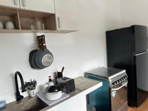 eine Küche mit einem schwarzen Kühlschrank und einem Herd in der Unterkunft Mimi Rae Villa Canggu in Dalung