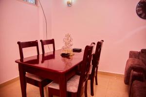 mesa de comedor con sillas, mesa y reloj en Kilimani Apartment 1, en Migombani 11 fotos más