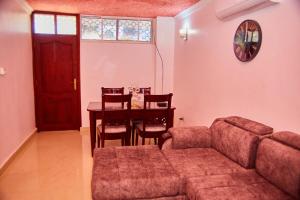 una sala de estar con un sofá y una mesa en Kilimani Apartment 1, en Migombani