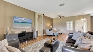 a living room with a couch and a tv at Valrico's Hidden Gem A Stunning 3-Bedroom Oasis Awaits! in Valrico