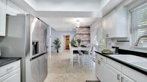 Lake MagdaleneにあるStunning Lake House w Heated Pool Ping Pong!の白いキャビネット付きのキッチン、ダイニングルーム