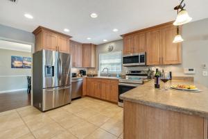 a kitchen with wooden cabinets and a stainless steel refrigerator at Exquisite Retreat with Heated Pool for 14 Guests, Pool Table Paradise! in Brandon