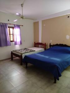 una camera con due letti e una finestra con tende viola di Depto comodo a La Banda