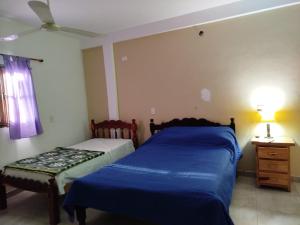 una camera da letto con due letti, un tavolo e una finestra di Depto comodo a La Banda