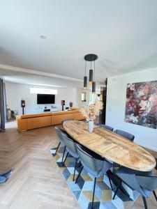 Soh Rent Maison - Villa Piscine Proche Strasbourg - TV - Wifi - Parking في Lampertheim: غرفة طعام مع طاولة وكراسي وأريكة