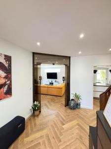 Soh Rent Maison - Villa Piscine Proche Strasbourg - TV - Wifi - Parking في Lampertheim: غرفة معيشة مع أريكة وتلفزيون