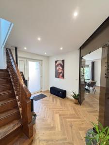 Soh Rent Maison - Villa Piscine Proche Strasbourg - TV - Wifi - Parking في Lampertheim: غرفة معيشة بها درج وأريكة