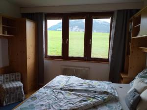 a bedroom with a bed and a large window at "Gletscherblick" in Bad Aussee +14 photos