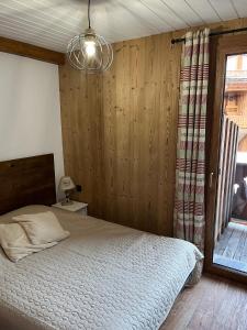 ein Schlafzimmer mit einem Bett und einem Fenster in der Unterkunft L'edelweiss in La Plagne Tarentaise