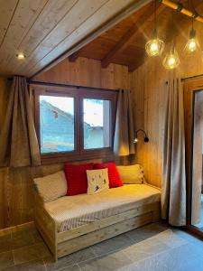 eine Bank in der Ecke eines Zimmers mit Fenster in der Unterkunft L'edelweiss in La Plagne Tarentaise