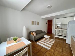 ein Wohnzimmer mit Sofa und Tisch in der Unterkunft De La Torre 1 in Guanarteme + 11 Fotos
