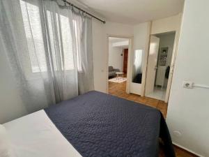 ein Schlafzimmer mit einem Bett mit einer blauen Bettdecke in der Unterkunft De La Torre 1 in Guanarteme