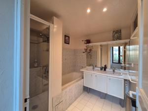 a bathroom with two sinks and a tub and a shower at Maison au calme en Chartreuse in Miribel-les-Échelles