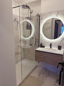 een badkamer met douche, wastafel en spiegel bij Panorama Majestic in Saint-Raphaël +9 foto's