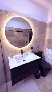 een badkamer met een wastafel en een spiegel bij Panorama Majestic in Saint-Raphaël