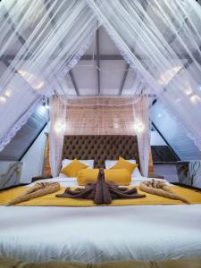 a large bed with a canopy in a room at White Moon Cabin & Cottage in Ella