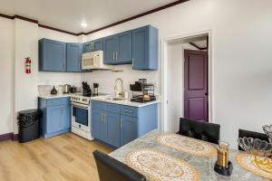 une cuisine avec des armoires bleues et une table dans l'établissement 7 Mi to Philly Stadiums! Charming Apartment, à Darby