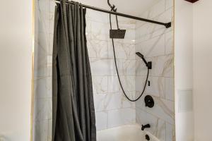 une douche avec un rideau de douche dans une salle de bain dans l'établissement 7 Mi to Philly Stadiums! Charming Apartment, à Darby 16 autres photos