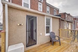 une chaise assise sur une terrasse devant une maison dans l'établissement 7 Mi to Philly Stadiums! Charming Apartment, à Darby