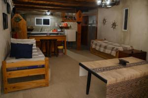 a living room with two beds and a kitchen at Cabaña Mbaretecua in Paso de la Patria