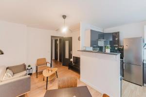 a kitchen and living room with a couch and a table at Les Jardins, T3 avec parking -2 voitures, 8min à pied de la gare in Lens +20 photos