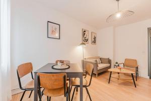a living room with a dining room table and chairs at Les Jardins, T3 avec parking -2 voitures, 8min à pied de la gare in Lens