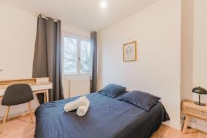 Les Jardins, T3 avec parking -2 voitures, 8min à pied de la gare في لونس: غرفة نوم عليها سرير مع زوج من الاحذية