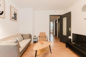 a living room with a couch and a table at Les Jardins, T3 avec parking -2 voitures, 8min à pied de la gare in Lens