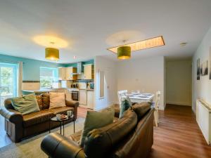 a living room with two leather couches and a kitchen at 2 Bed in Sanquhar 89402 in Sanquhar