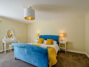 a bedroom with a blue bed and a blue couch at 2 Bed in Sanquhar 89402 in Sanquhar