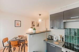 a kitchen with a table and a dining room at Les Jardins, T3 avec parking -2 voitures, 8min à pied de la gare in Lens