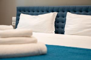 a bed with a blue headboard and white pillows at Palazzo Machiavelli Trieste in Trieste