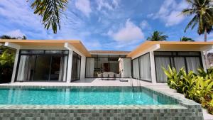 een huis met een zwembad ervoor bij White Lotus Villa in Ban Madua Wan