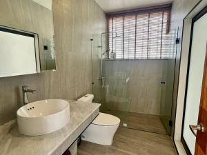 een badkamer met een wastafel, een toilet en een douche bij White Lotus Villa in Ban Madua Wan