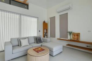 een woonkamer met een bank en een salontafel bij White Lotus Villa in Ban Madua Wan