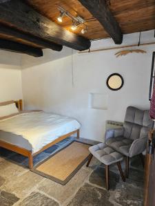 a bedroom with a bed and a chair at Casa Mönä in Corippo